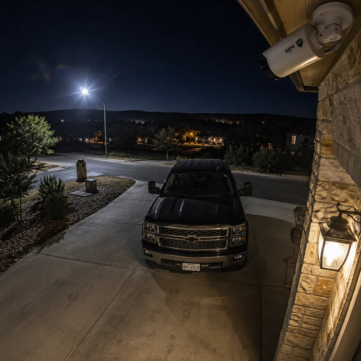 Low-light security camera footage view of a residential driveway at night